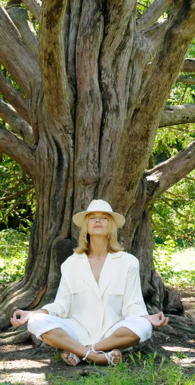 woman meditates under of a tree